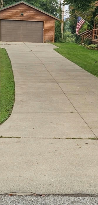 The same driveway bright and evenly clean after power washing