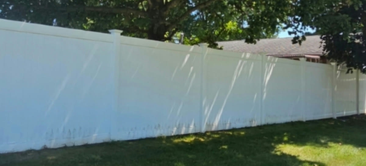 The same white vinyl fence bright and spotless after soft washing
